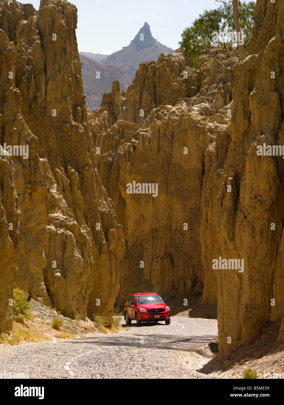 Red car winding road yellow rocky mountain trip touristic peak curve landscape vertical 4x4 truck panoramic rout scenery view Stock Photo