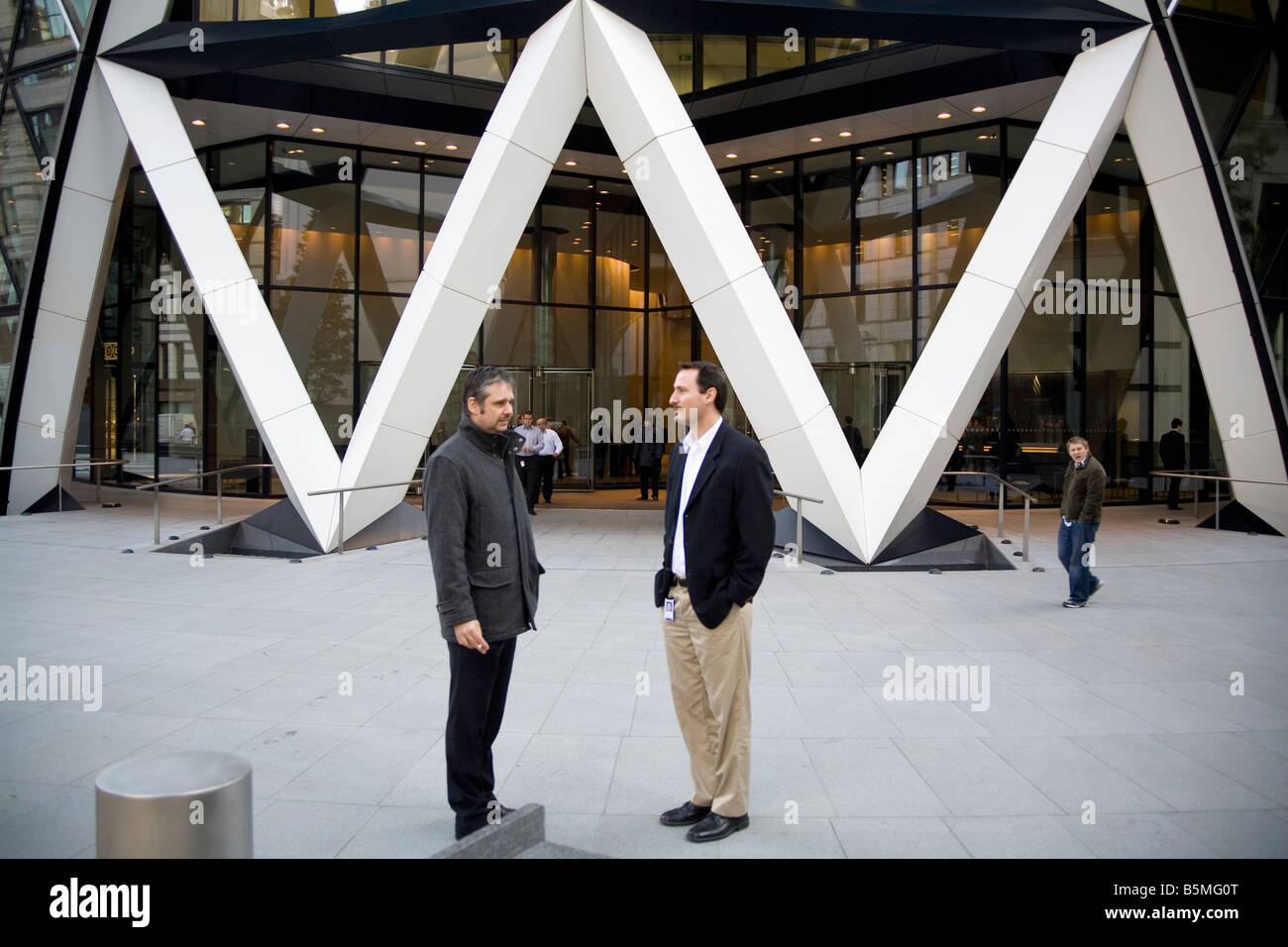 Two man at the entrance of the 'Swiss re' tower in the City of London England UK Stock Photo