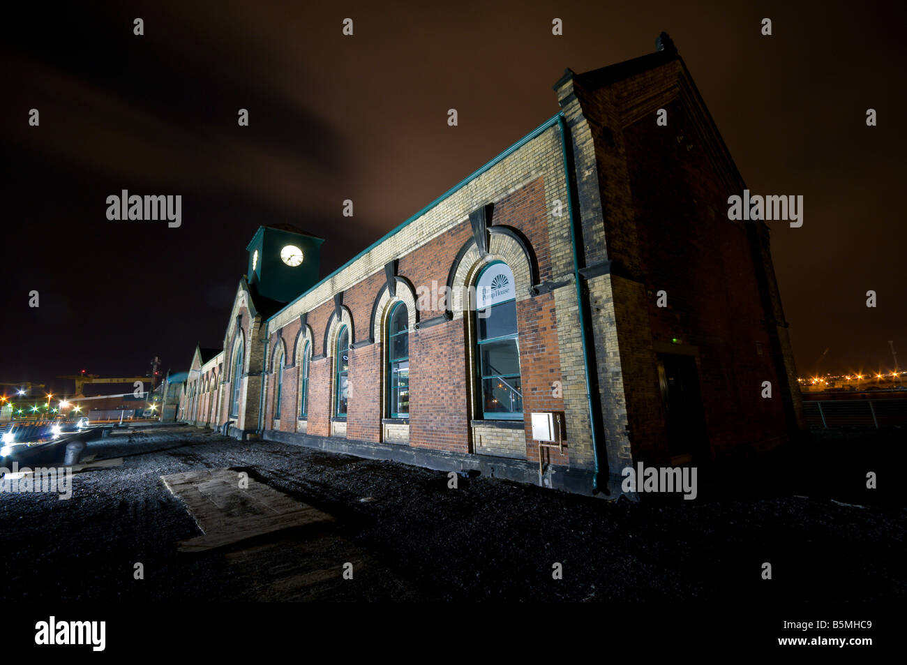 Thompsons Pump House, Thompsons Graving Dock, Belfast, at night.  Harland and Wolff cranes in the background Stock Photo