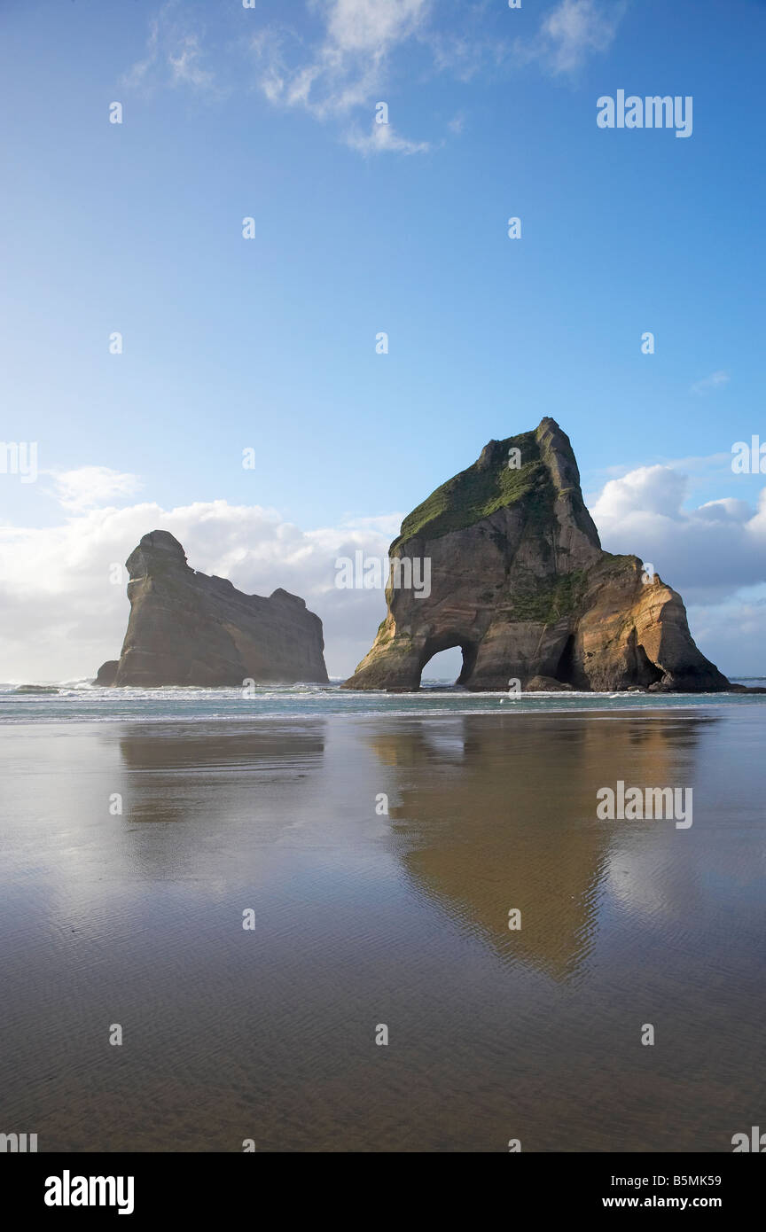 Archway Islands Reflected in Wet Sands of Wharariki Beach near Cape Farewell North West Nelson Region South Island New Zealand Stock Photo