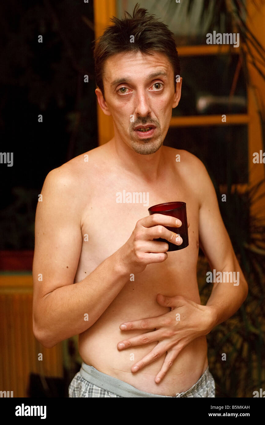 alcoholic man drinking and  having stomach ache Stock Photo