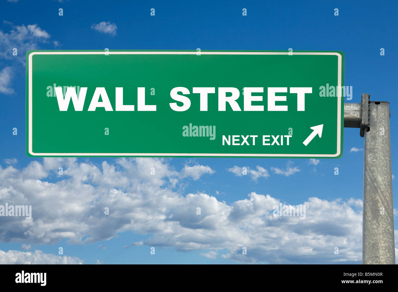 A large green traffic sign with wall street on it Stock Photo