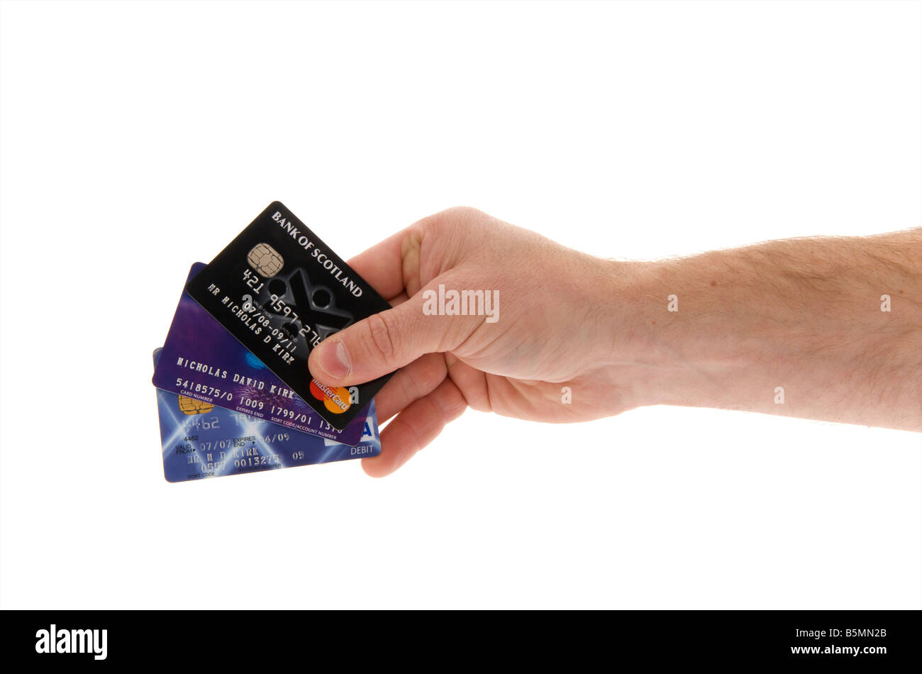 mans male right outstretched hand holding a selection of credit cards against a white background Stock Photo