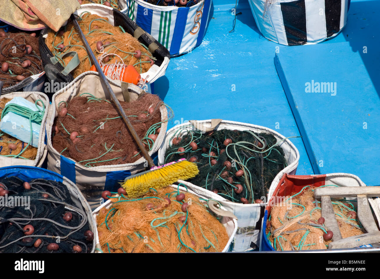 Fishing nets of different colours. Yellow, green, red orange, brown on blue azure fishing boat main deck Stock Photo