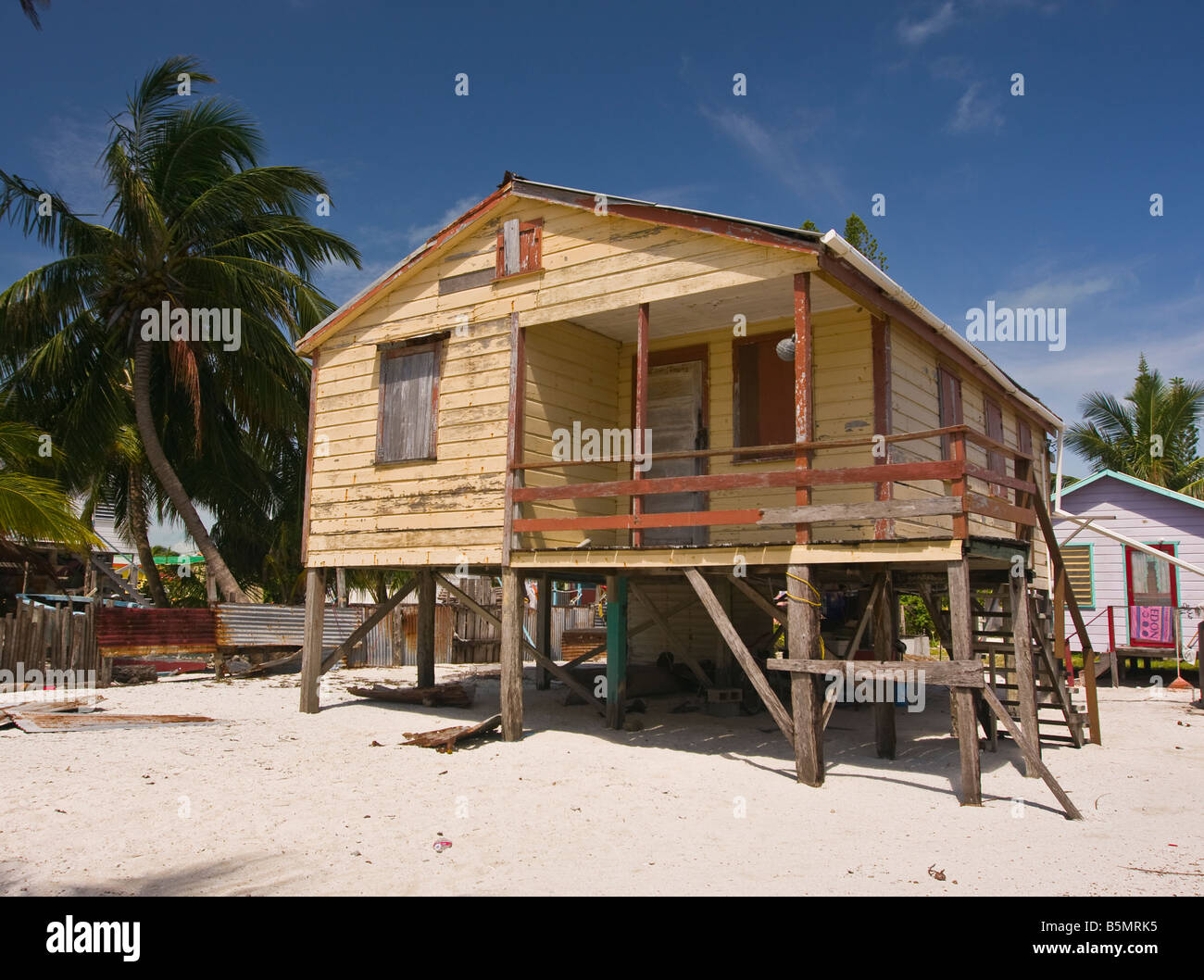 CAYE CAULKER BELIZE Wooden house on stilts on sand beach with palm trees Stock Photo