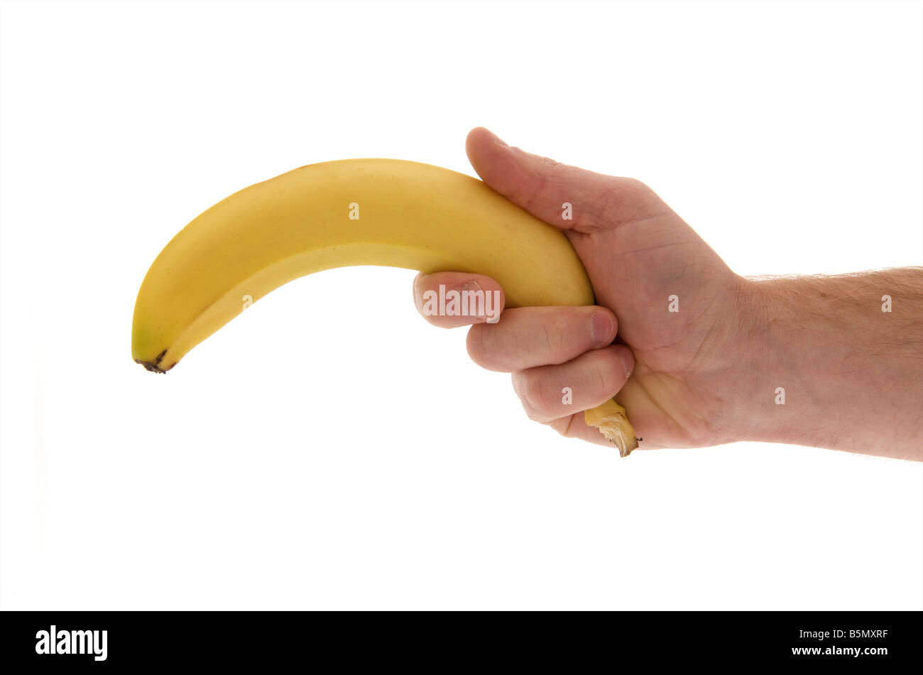 mans male right outstretched hand holding a banana like a gun against a white background Stock Photo