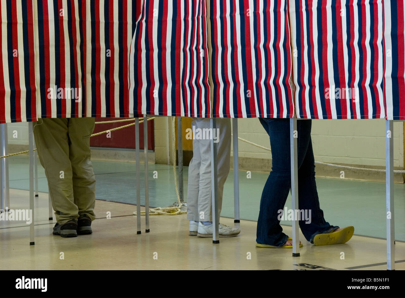 Voters legs behind the curtain Stock Photo