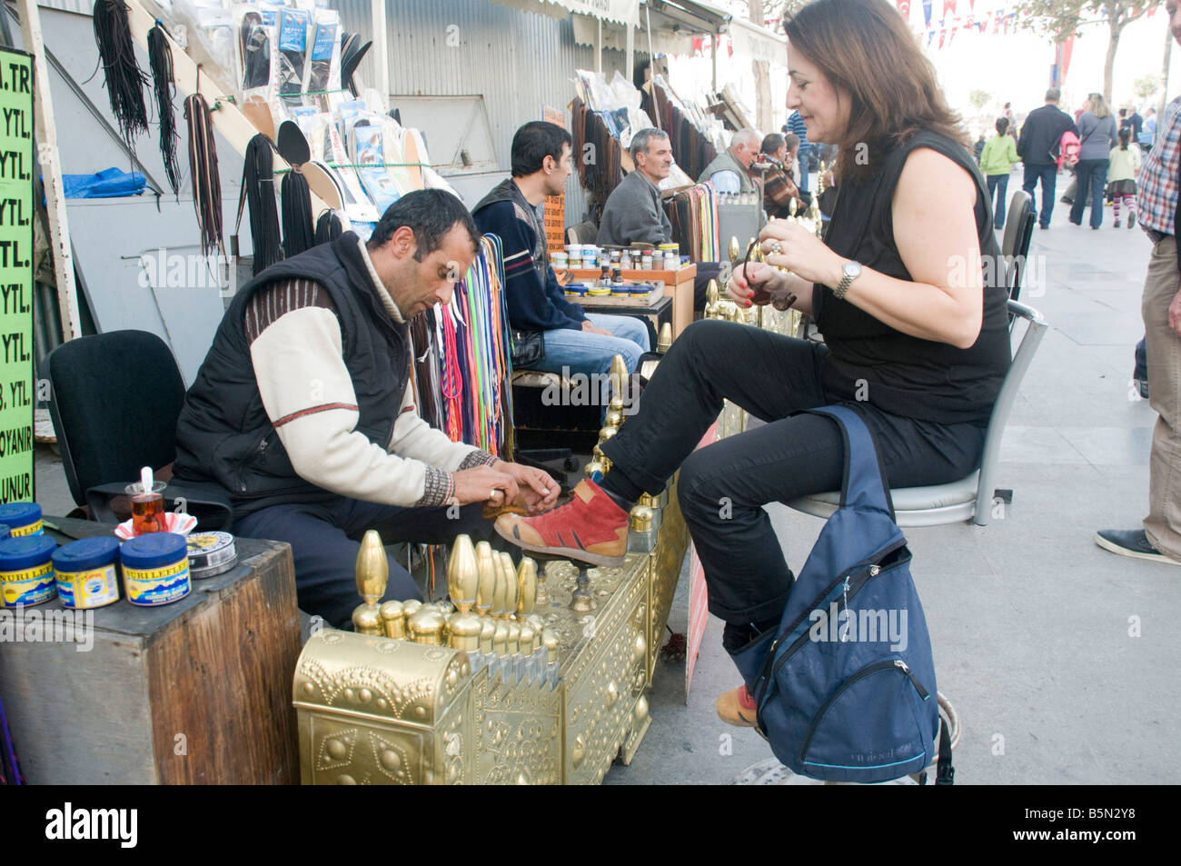 Turkey Istanbul Shoeshine stand female client having her shoes polished Stock Photo