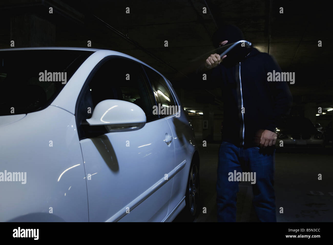 Thief breaking window of car with Crowbar Stock Photo Alamy