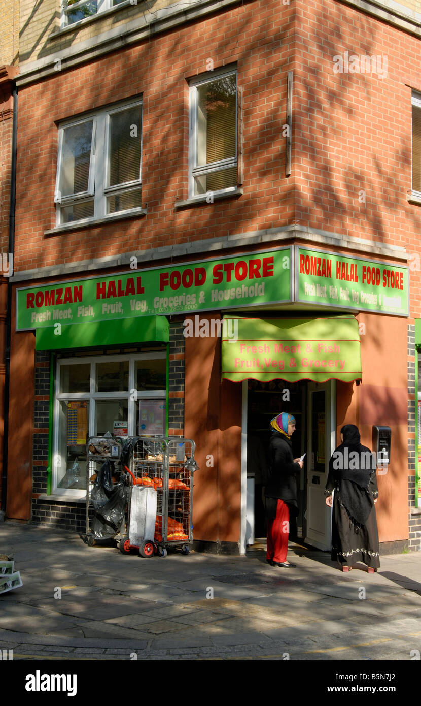 Halal food store with two women talking in doorway, King's Cross, London, England Stock Photo