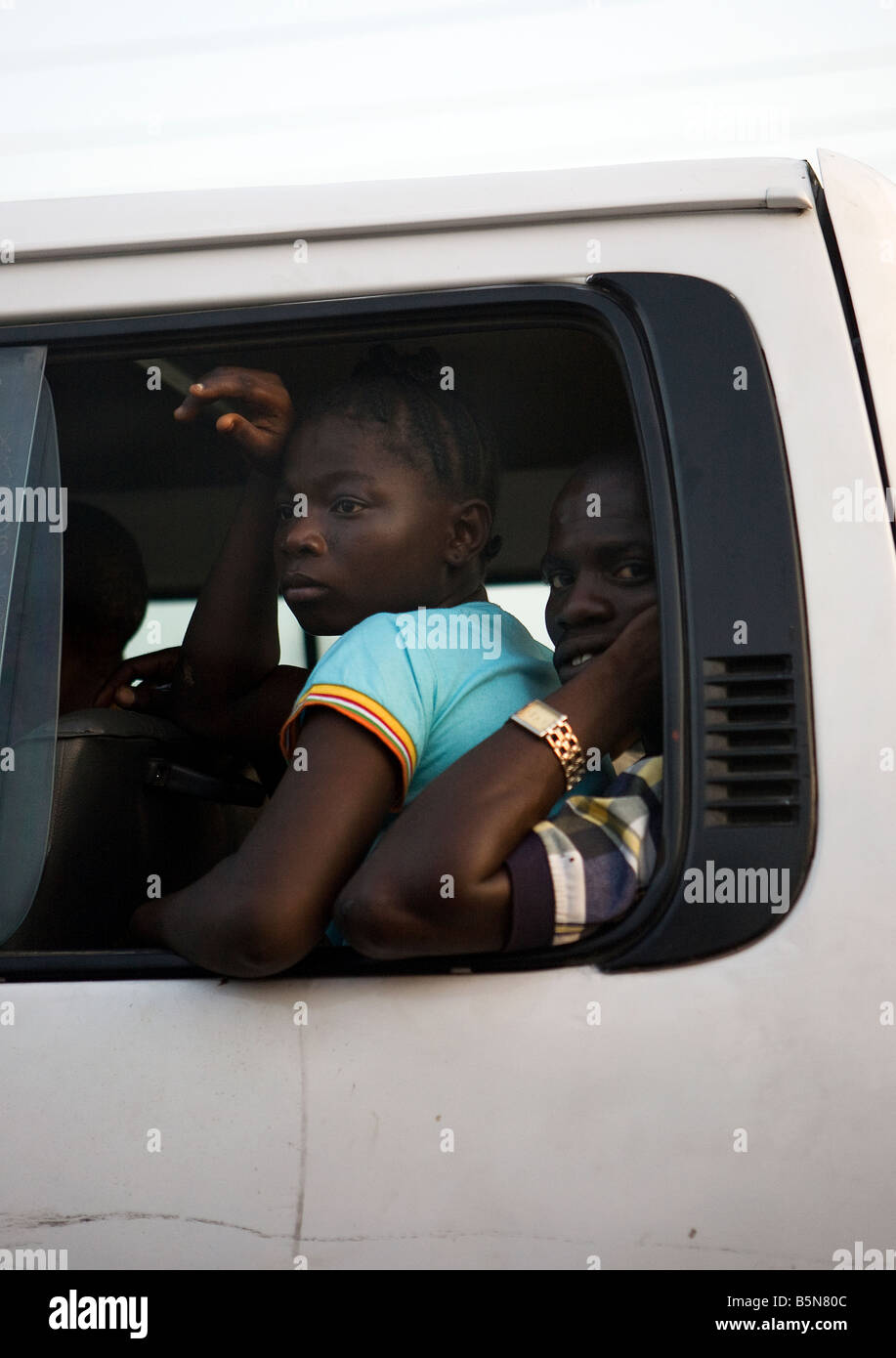 Picture through a window of an overcrowded bus leaving Lago, Nigeria, where it is essential to share a seat Stock Photo