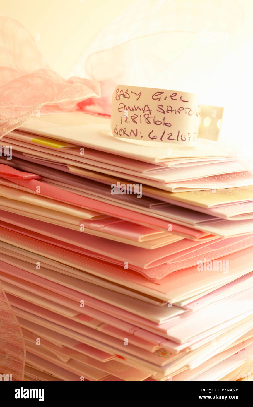 Stack of congratulation gift cards with new baby hospital identification name tag on top Stock Photo