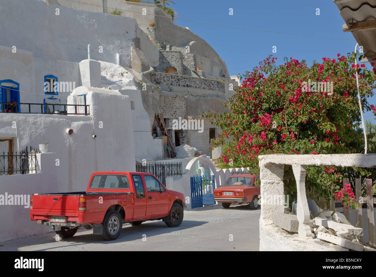 Street with red pick-up truck in the traditional village of Vothonas, Santorini Island, Greece Stock Photo