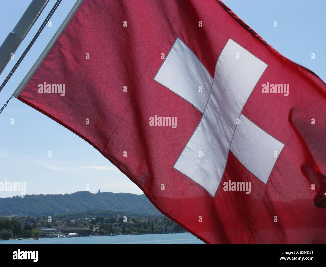 Swiss national flag with mountain range in the background Stock Photo