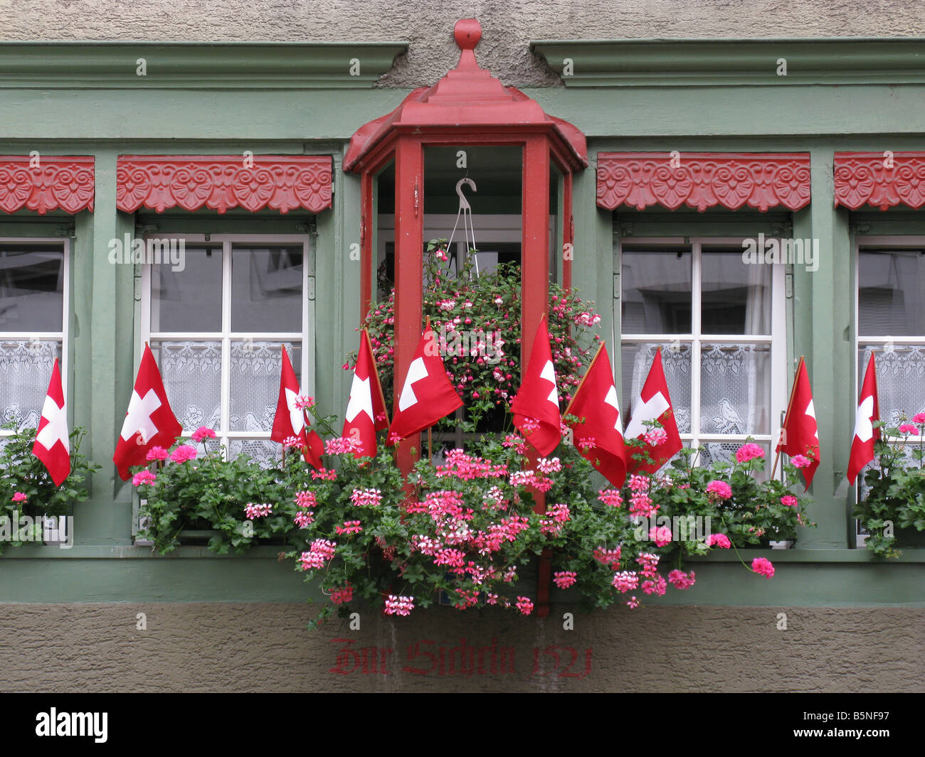 Windows decorated with little swiss flags and flowers Stock Photo