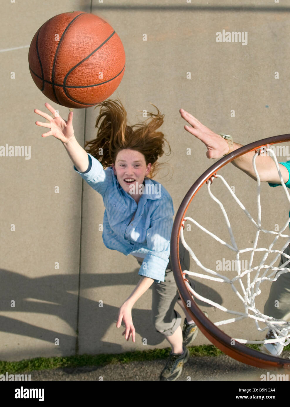 woman playing basketball outdoors shooting basket Stock Photo