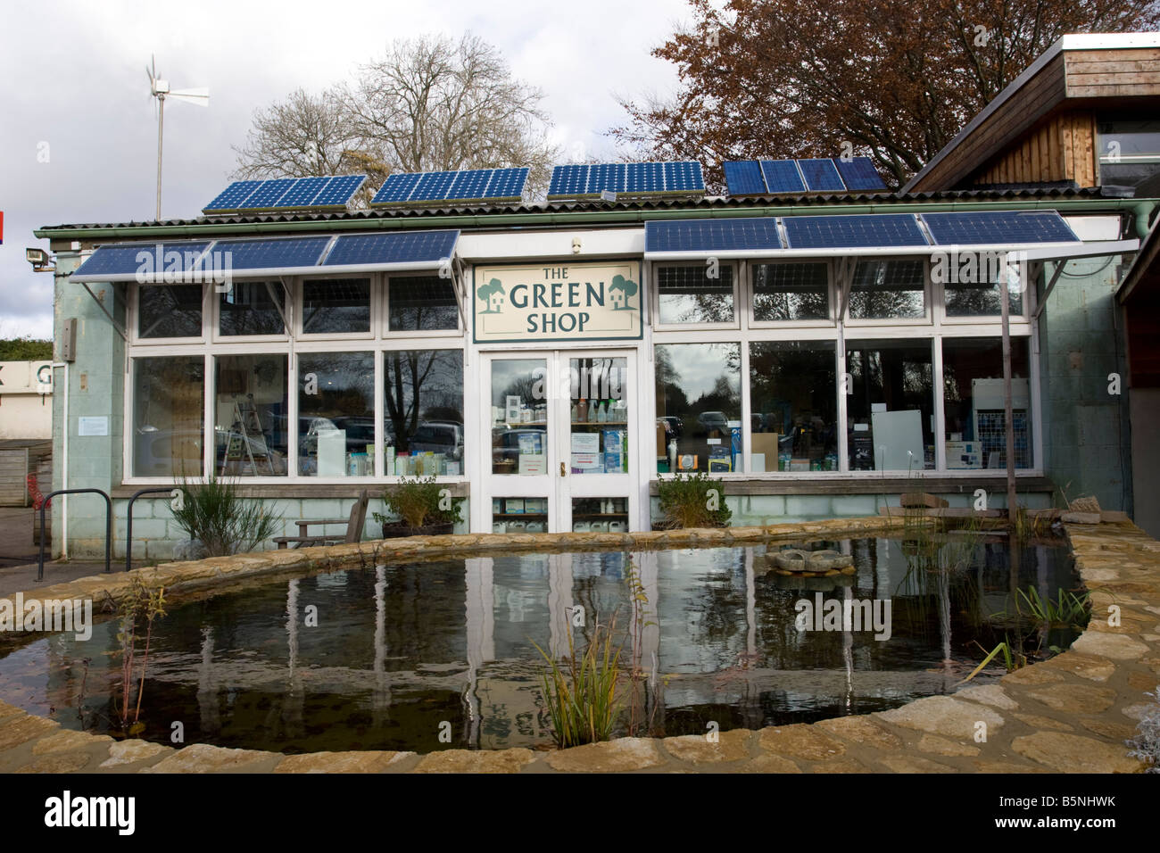 Solar PV wind turbine and pond The Green Shop Bisley Stroud UK Stock Photo
