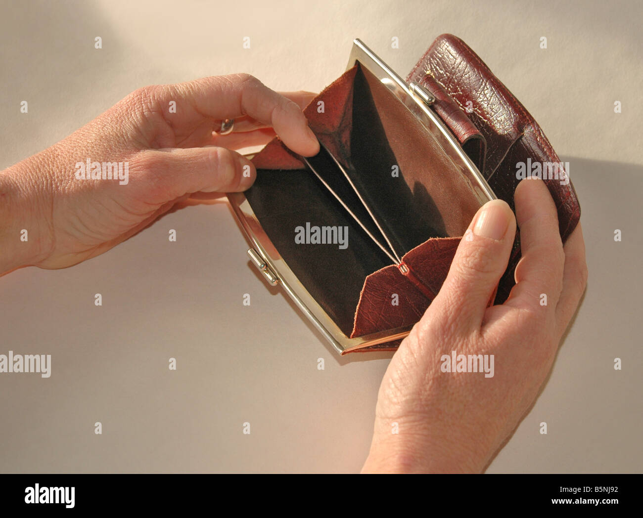 A woman looks for money in an apparent empty purse Stock Photo Alamy