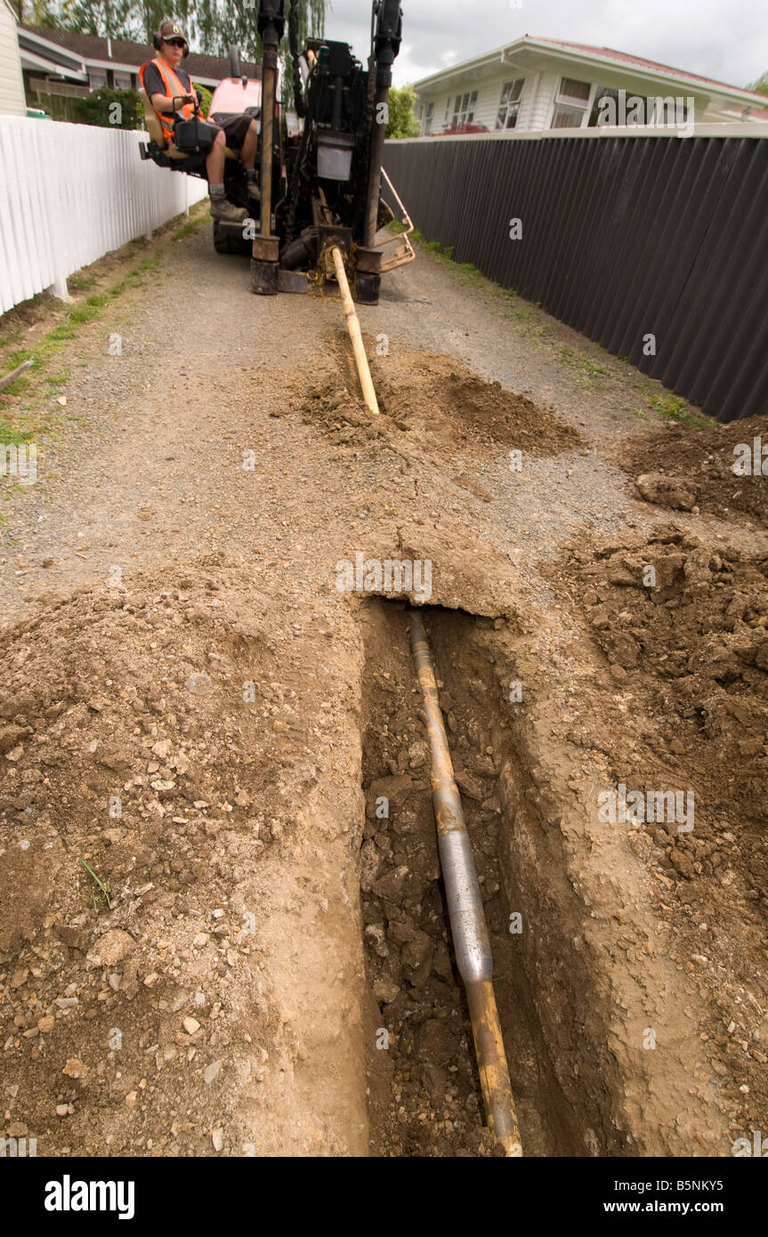 Men drilling under ground holes for water pipes with a ditch witch