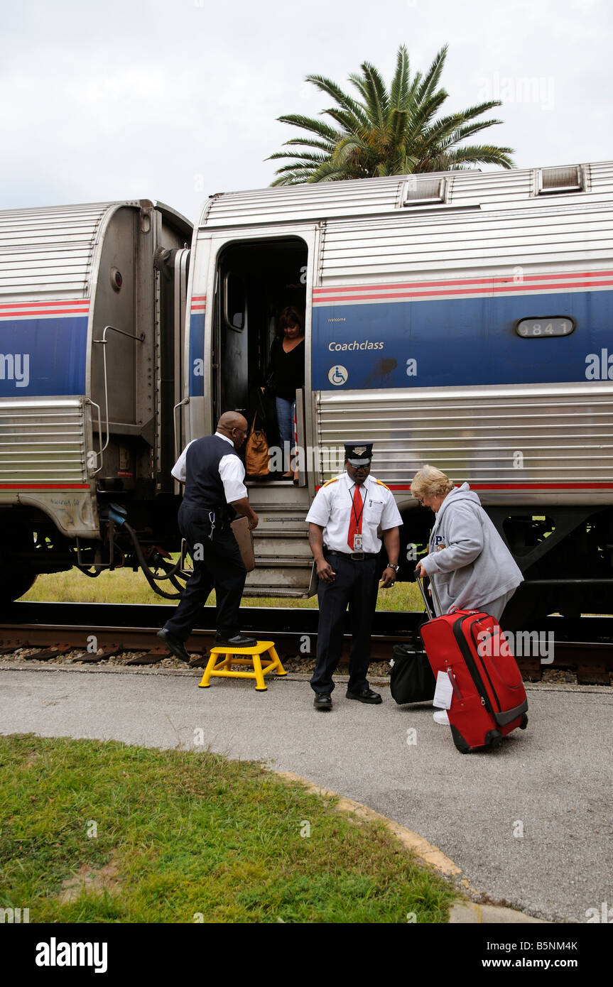 Railroad conductors assisting passengers onto hires stock photography