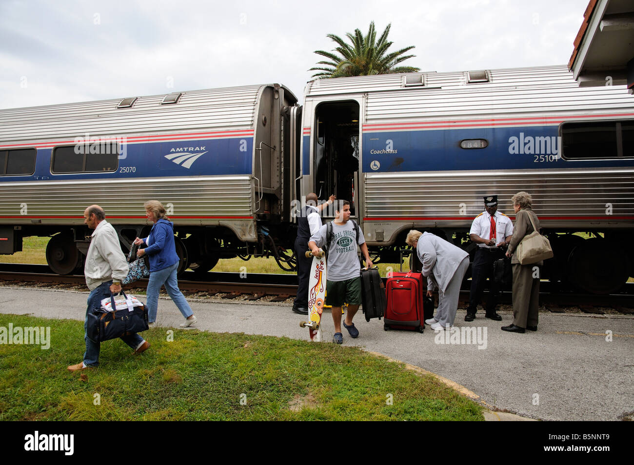 Amtrak railroad conductors assisting passengers from train America USA