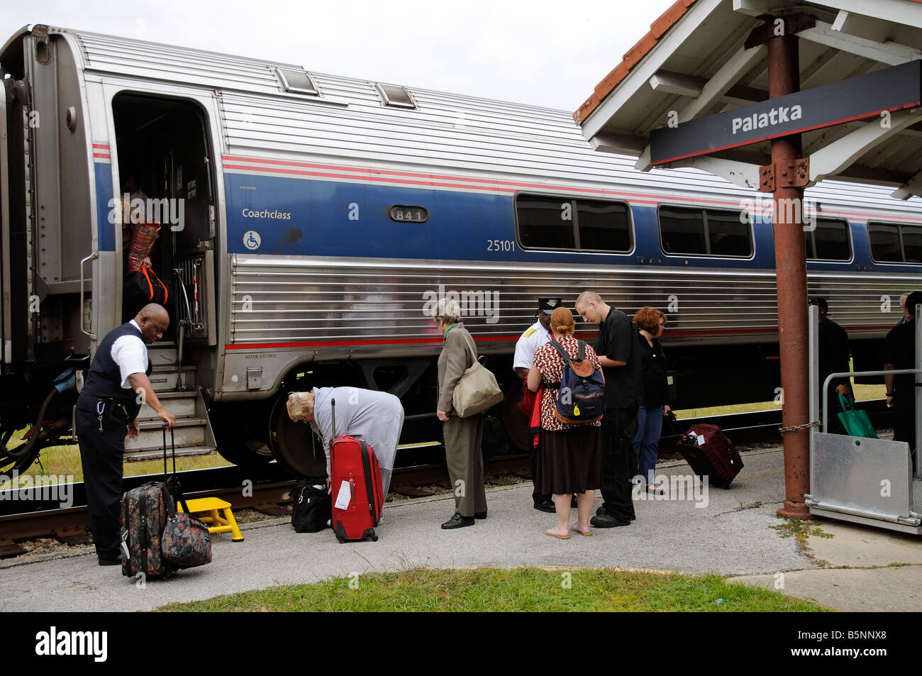 Amtrak railroad conductors assisting passengers train America USA Stock