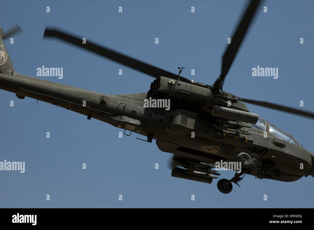 AH 64 Apache Helicopter overflying the green zone in baghdad against a blue sky Stock Photo