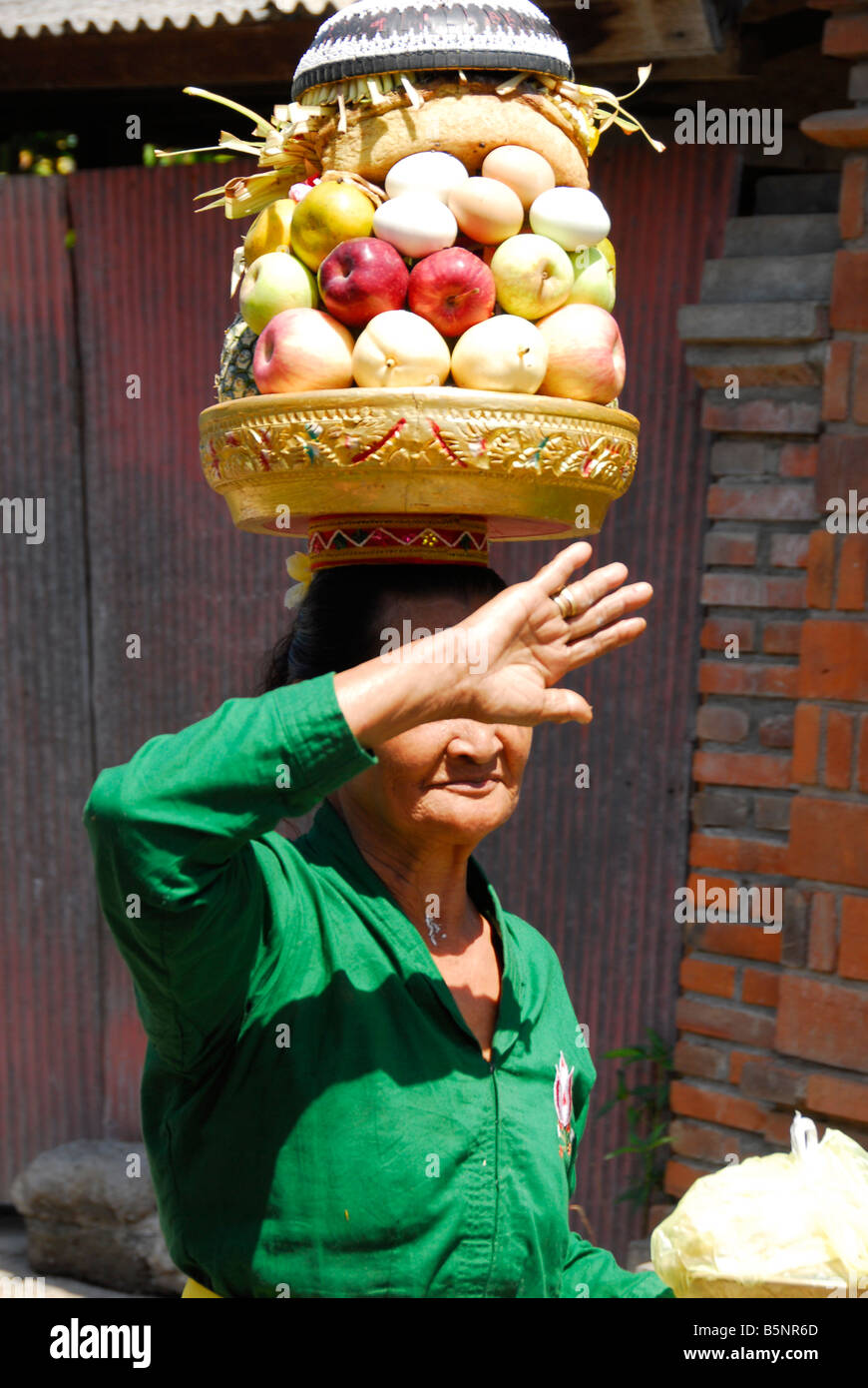 Balinese woman is going to offering during strong sunshine, Bali, Indonesia Stock Photo