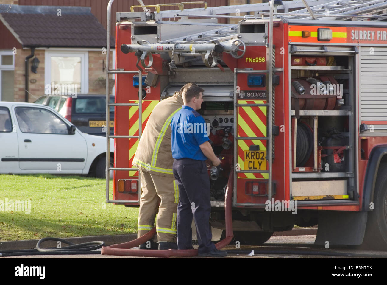 Firemen at the Rear of a Fire Engine Stock Photo