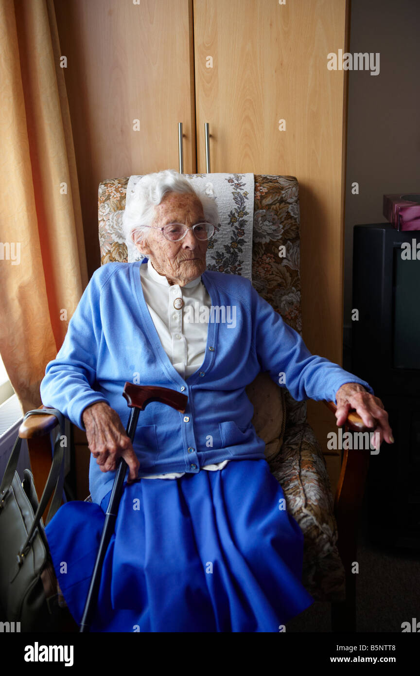 Elderly lady sitting in chair by window in old peoples home Stock Photo ...