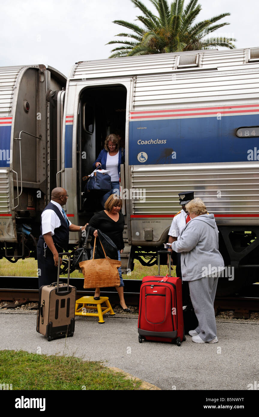 Amtrak railroad conductors assisting passengers from train America USA