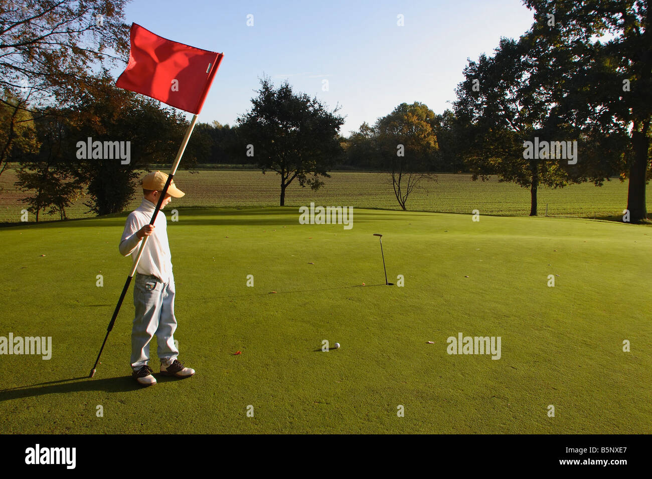 golf green putt boy with flag Stock Photo