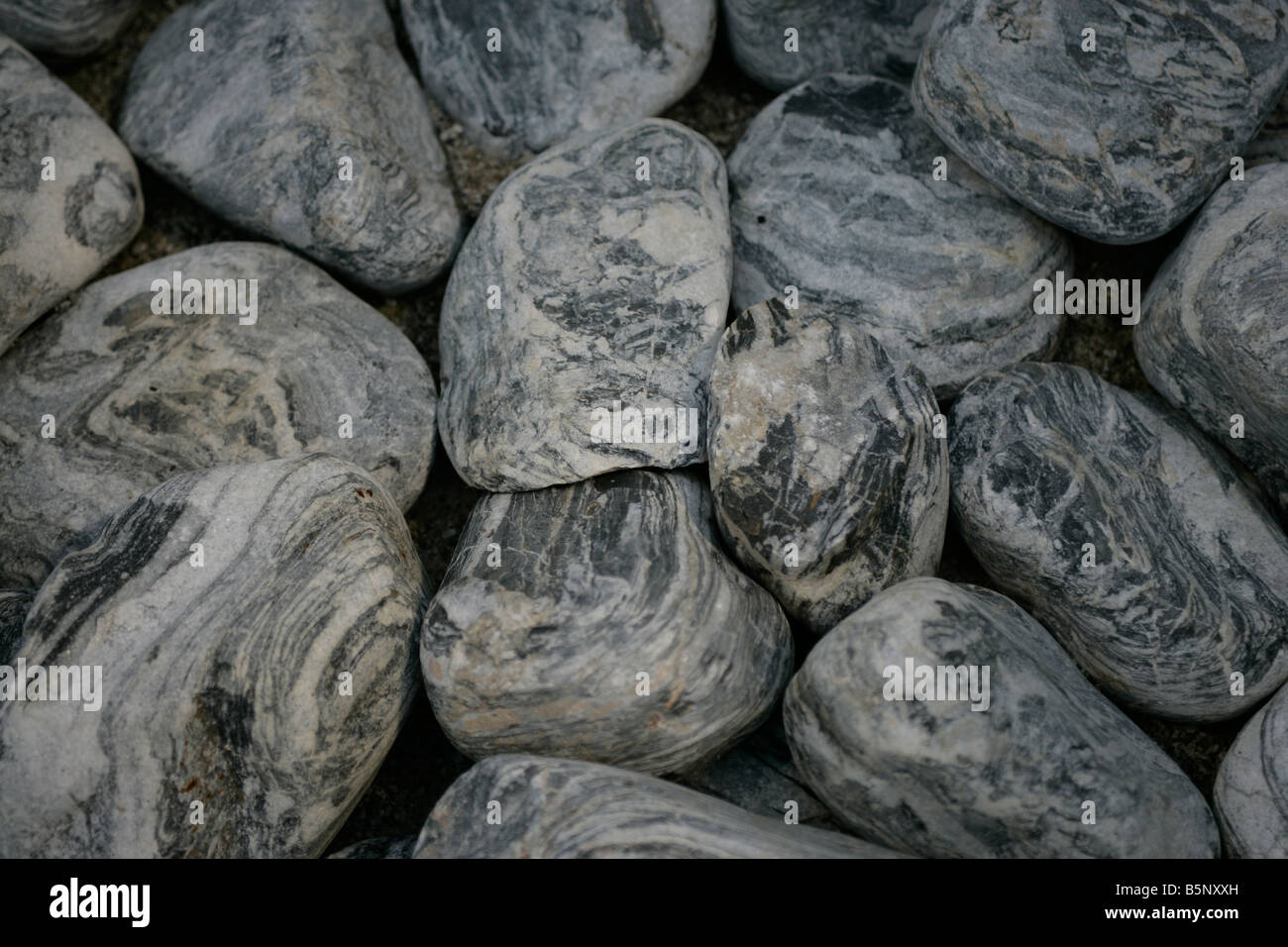 Black, Grey and white pebbles on a beach Stock Photo