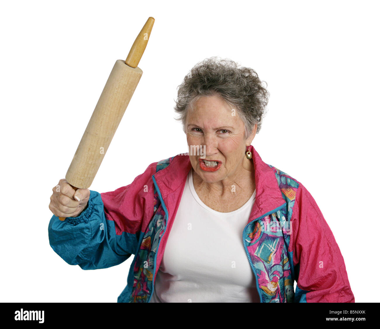 A very angry senior lady holding a rolling pin and threatening to whack someone with it her husband Isolated on white Stock Photo