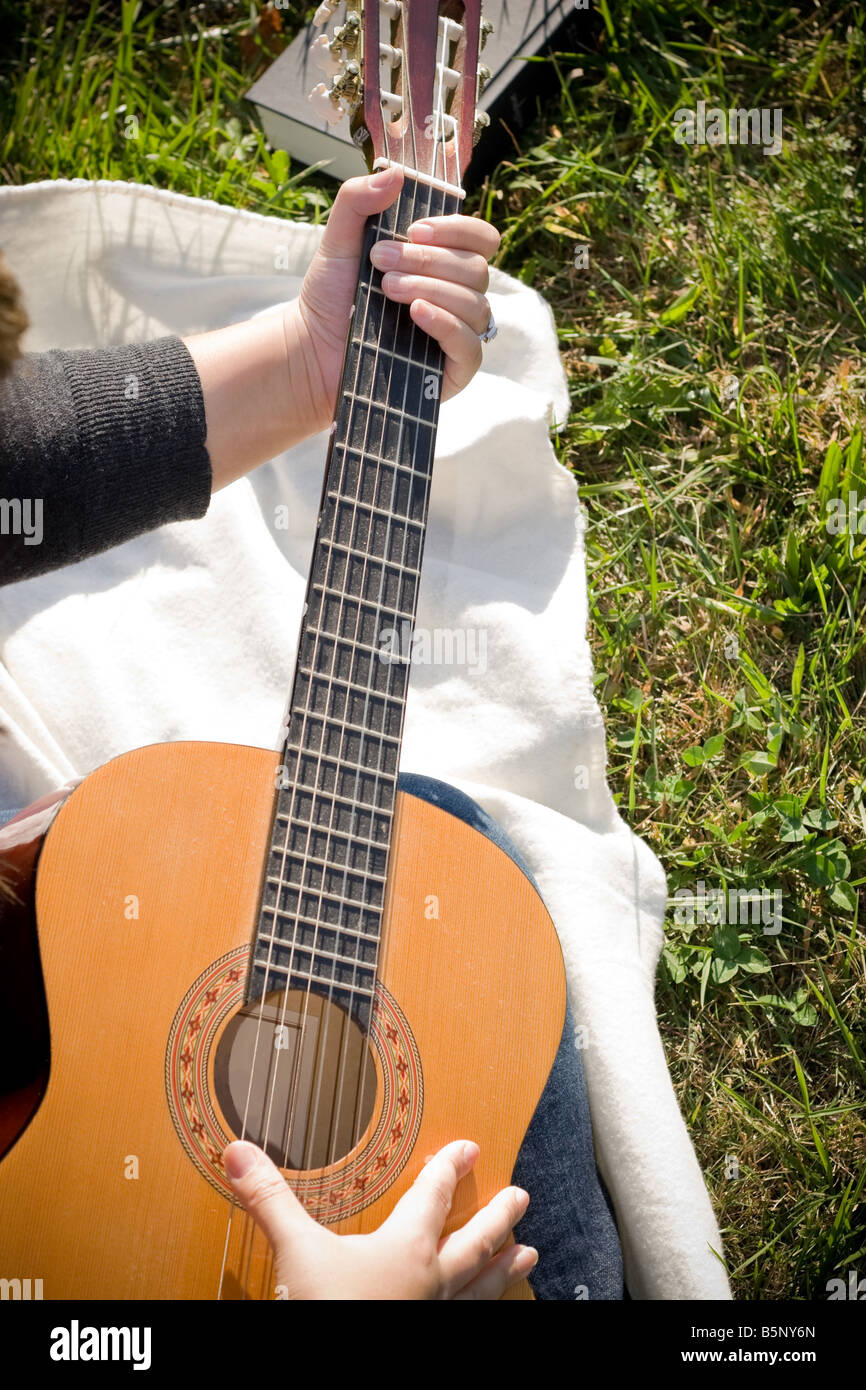 Portrait of a young Spanish woman playing her acoustic guitar. Stock Photo