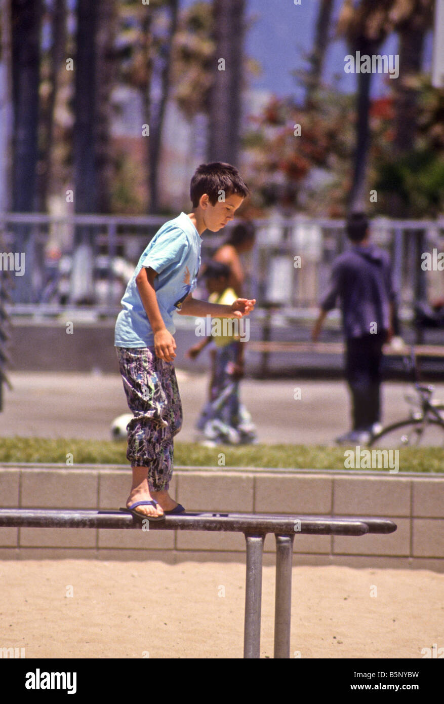 Boy balances on metal parallel bars in public park Stock Photo - Alamy