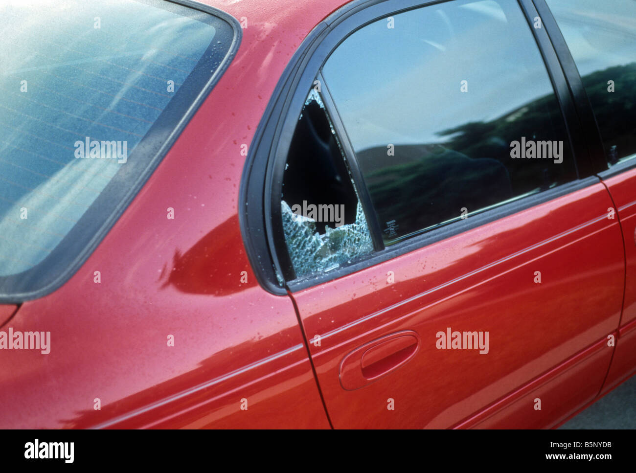 Broken rear side window of red car Stock Photo Alamy