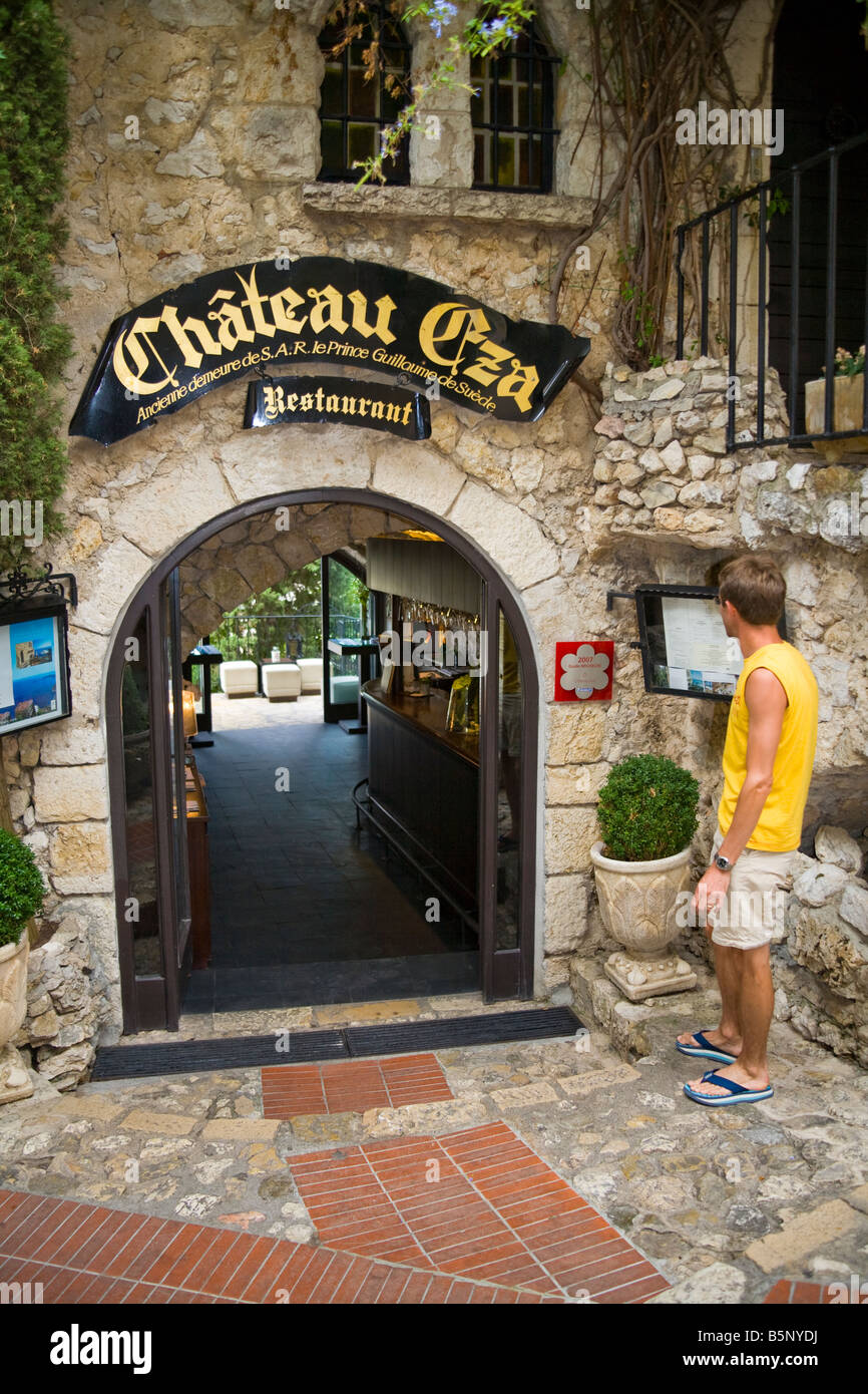 Tourist standing outside Chateau Eza Restaurant, in the medieval village of Eze, near Monaco, France Stock Photo