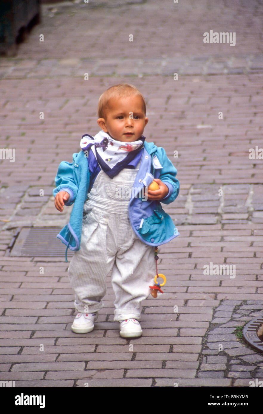 German toddler walks on his cobbled street Stock Photo