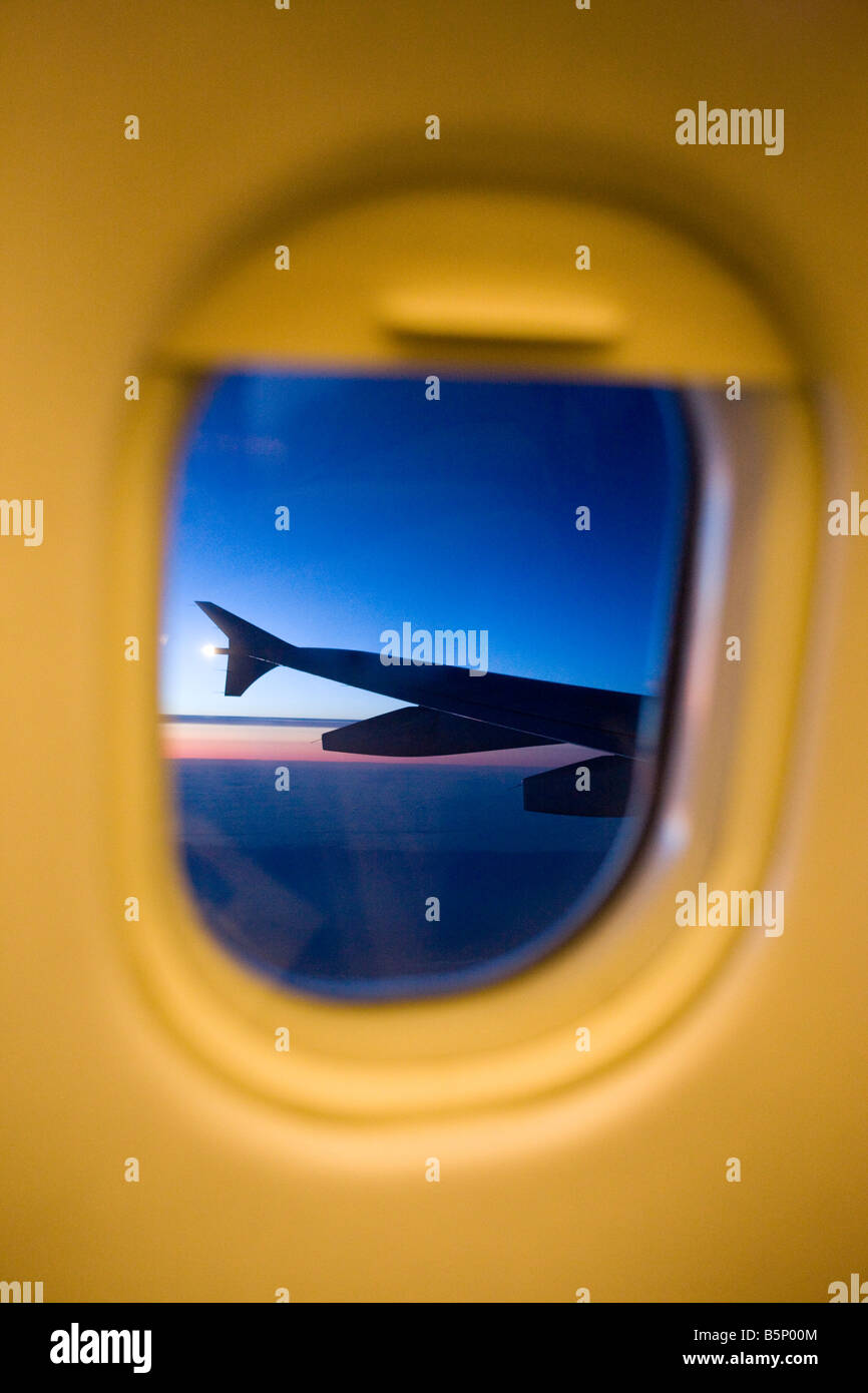 TWILIGHT VIEW THROUGH COMMERCIAL AIRLINER PASSENGER CABIN WINDOW FRAME Stock Photo