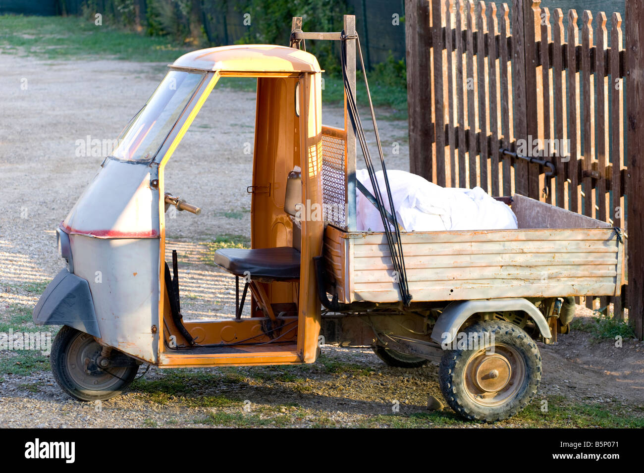 Well used Ape three wheeled utility vehicle in Tuscan village, near Monte San Savino, Italy. Stock Photo