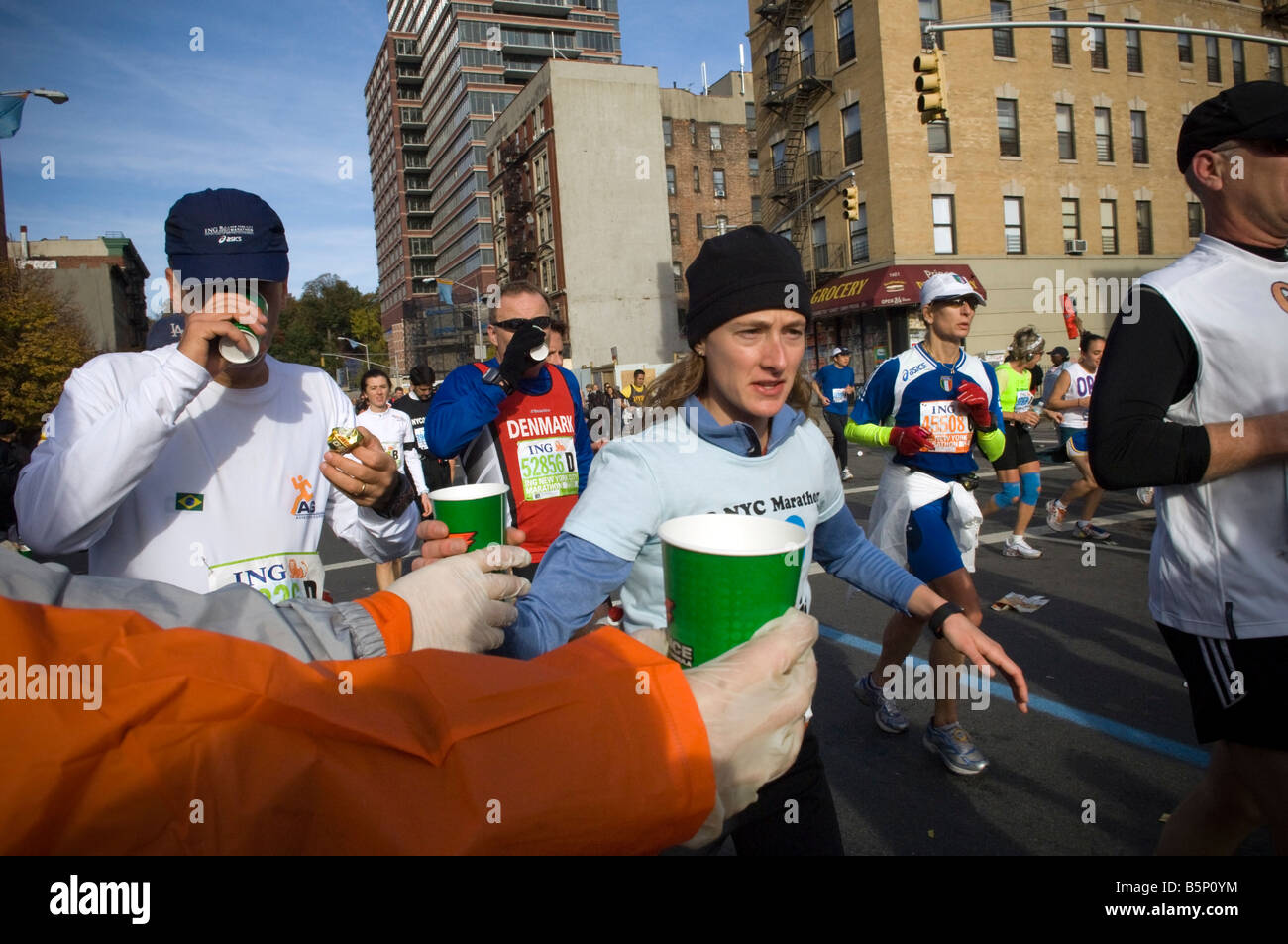 Runners pass through Harlem at the 22 mile marker near Mount Morris ...