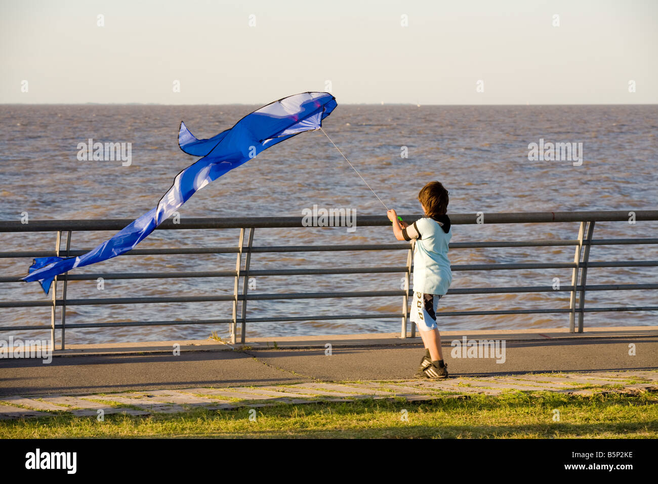 Child flying a blue kite Stock Photo