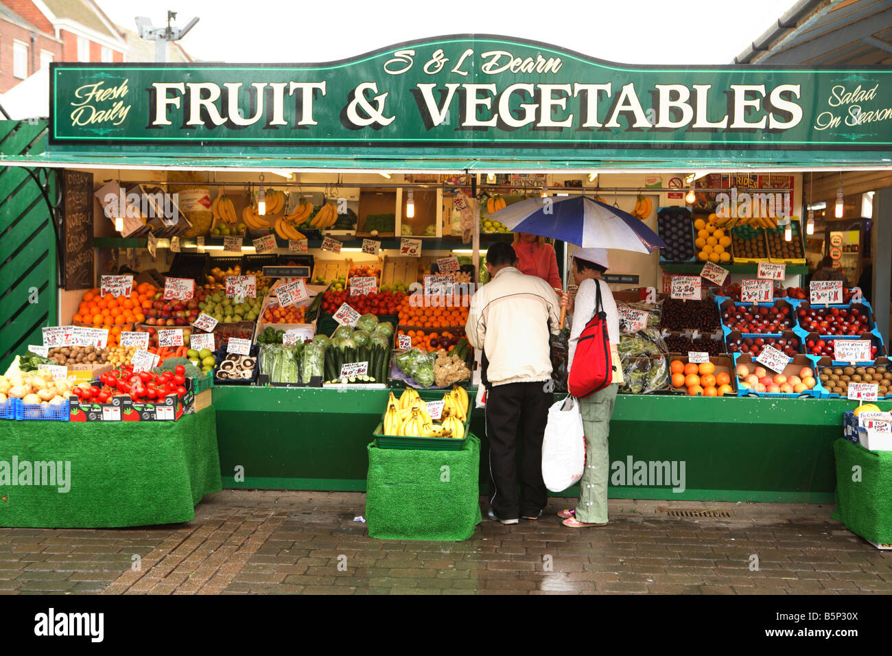 A vegetable stall in the Market Square Great Yarmouth during a summer downpour jy 17 2008 Stock Photo