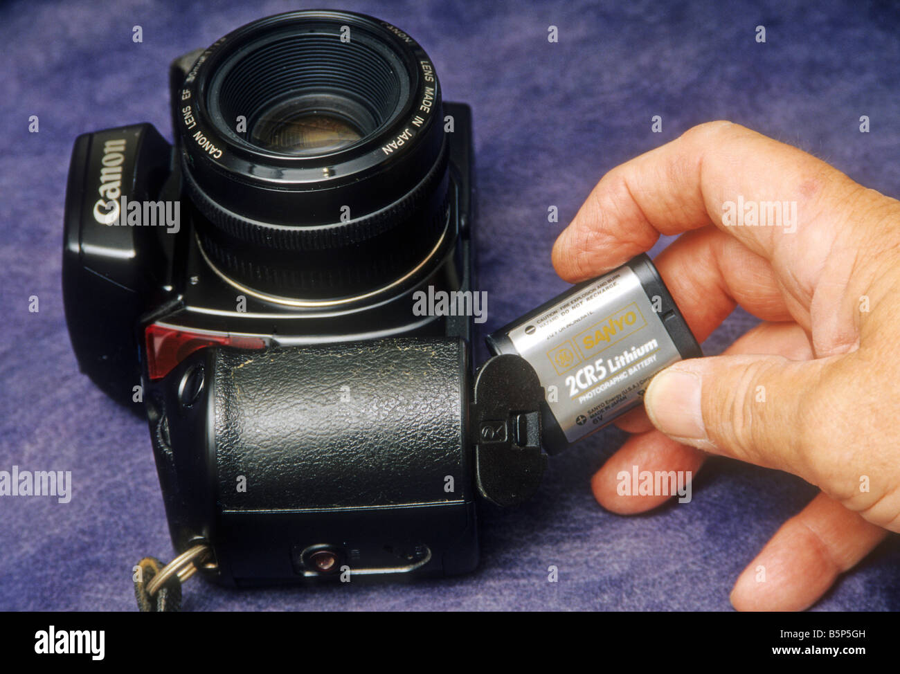 Battery is inserted into Canon 35mm camera Stock Photo - Alamy