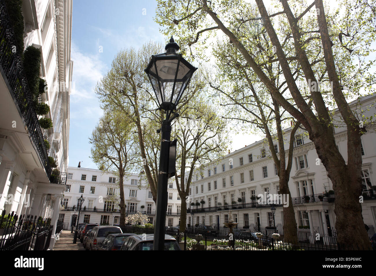Immaculate and identical white-painted properties and ornamental lamp post in exclusive Wellington Square, London SW3 Stock Photo
