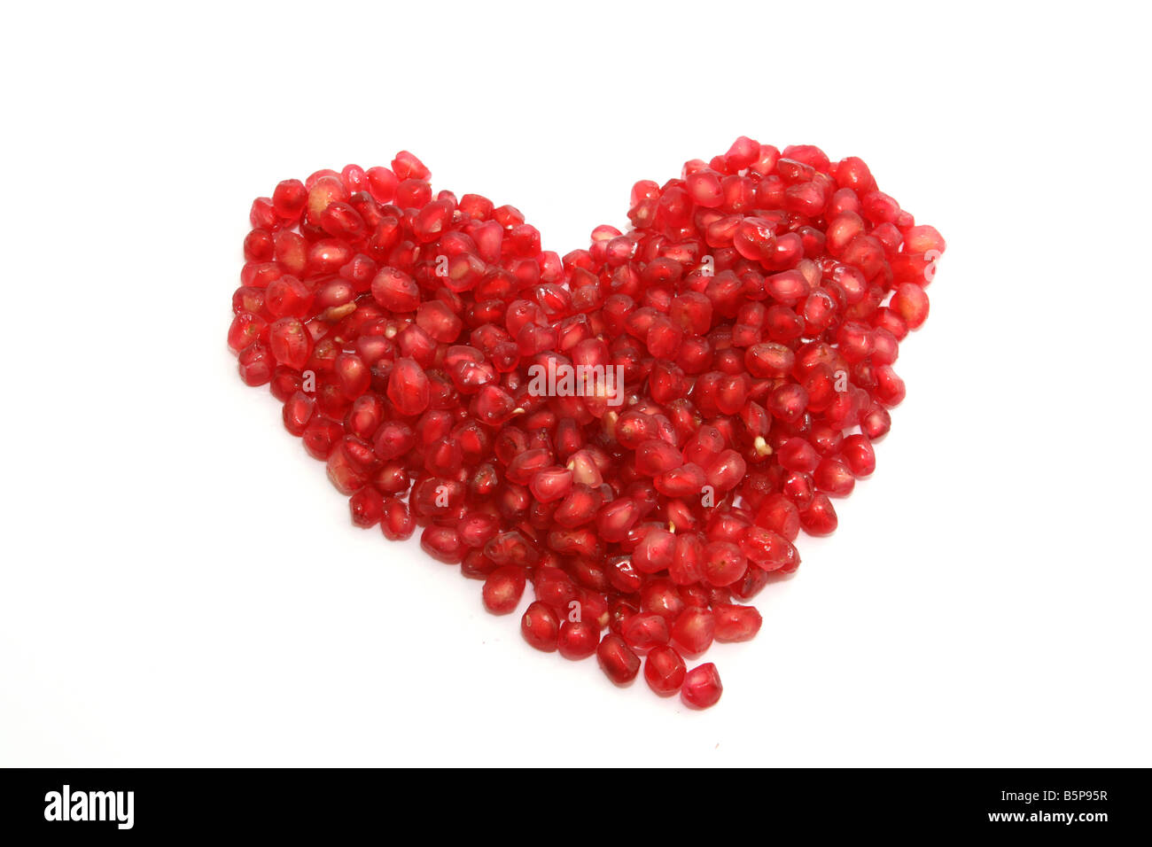 red hart from pomegranate seeds isolated on white background Stock Photo