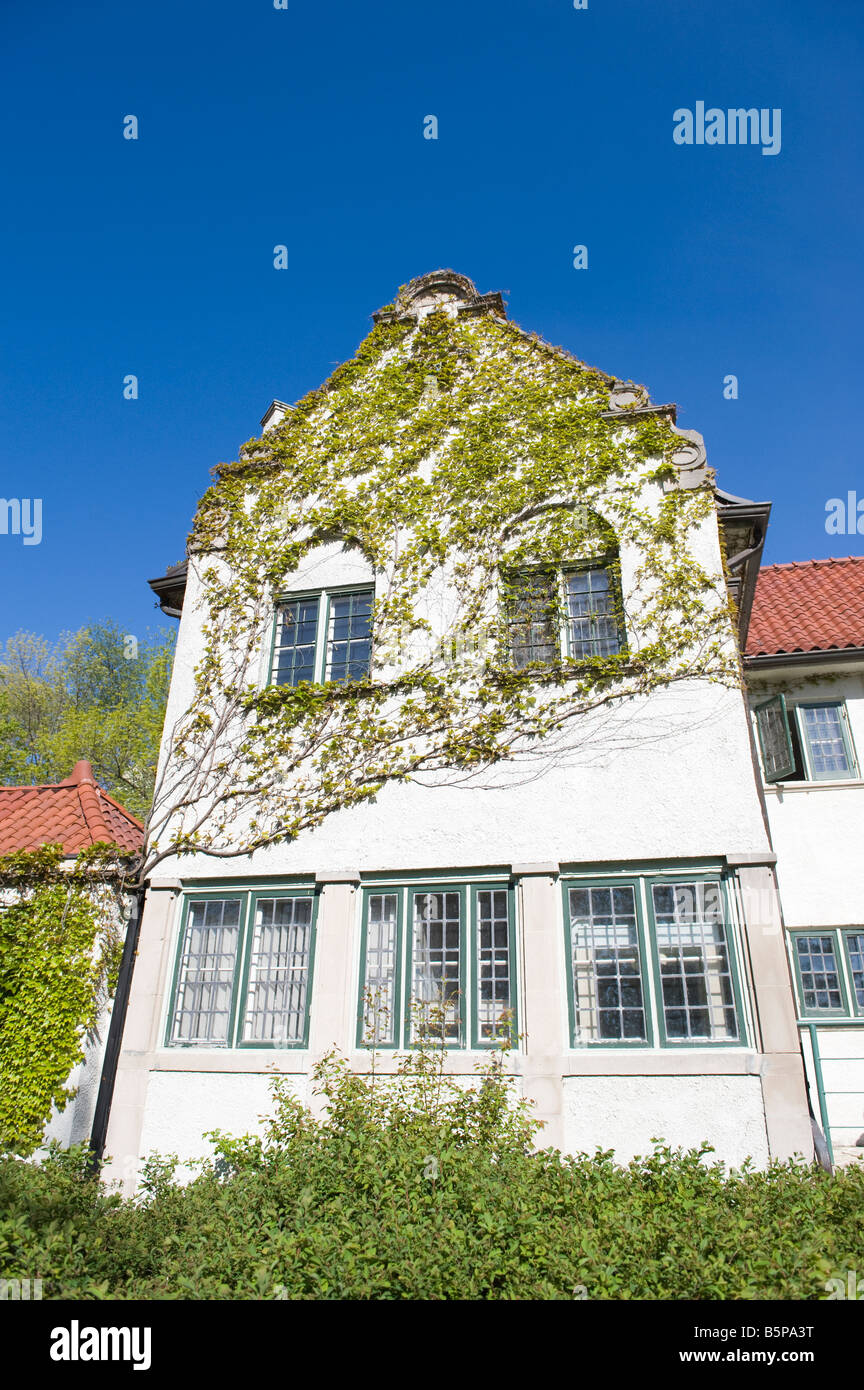 Facade of an old estate home with clay tile roof against clear blue sky in springtime Stock Photo