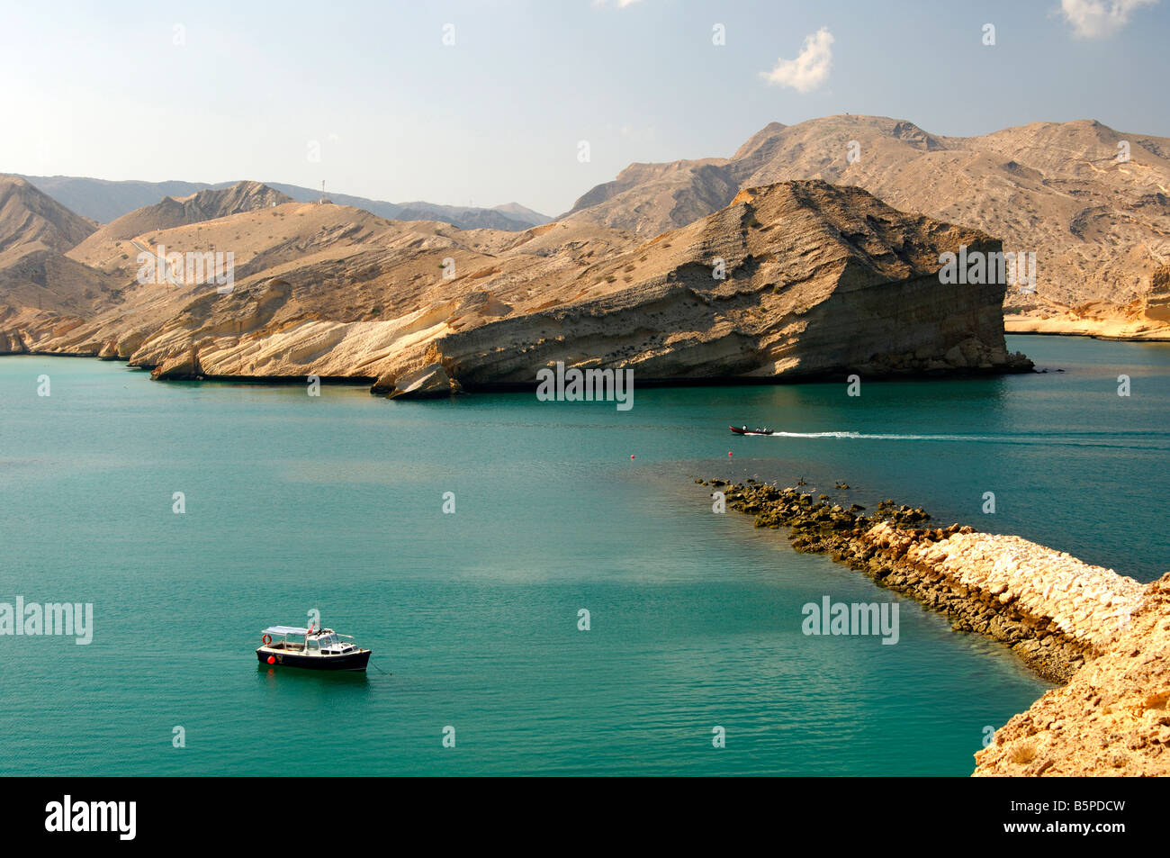 Entrance to the Bay of Barr Al Jissah nestled between high arid rocky mountains near Muscat, Sultanate of Oman Stock Photo