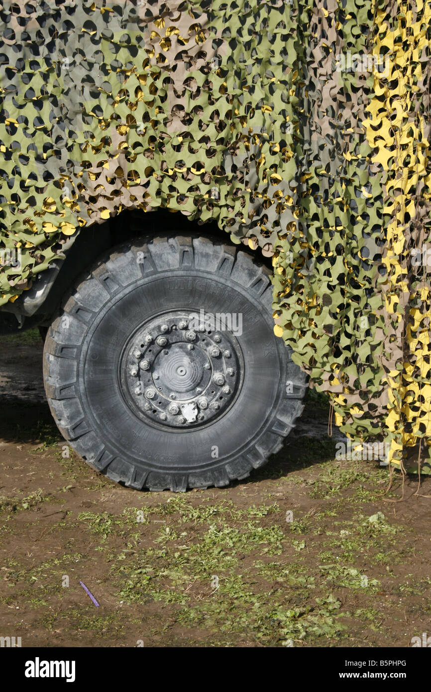 vehicle by camouflage military army base tent at open day Stock Photo